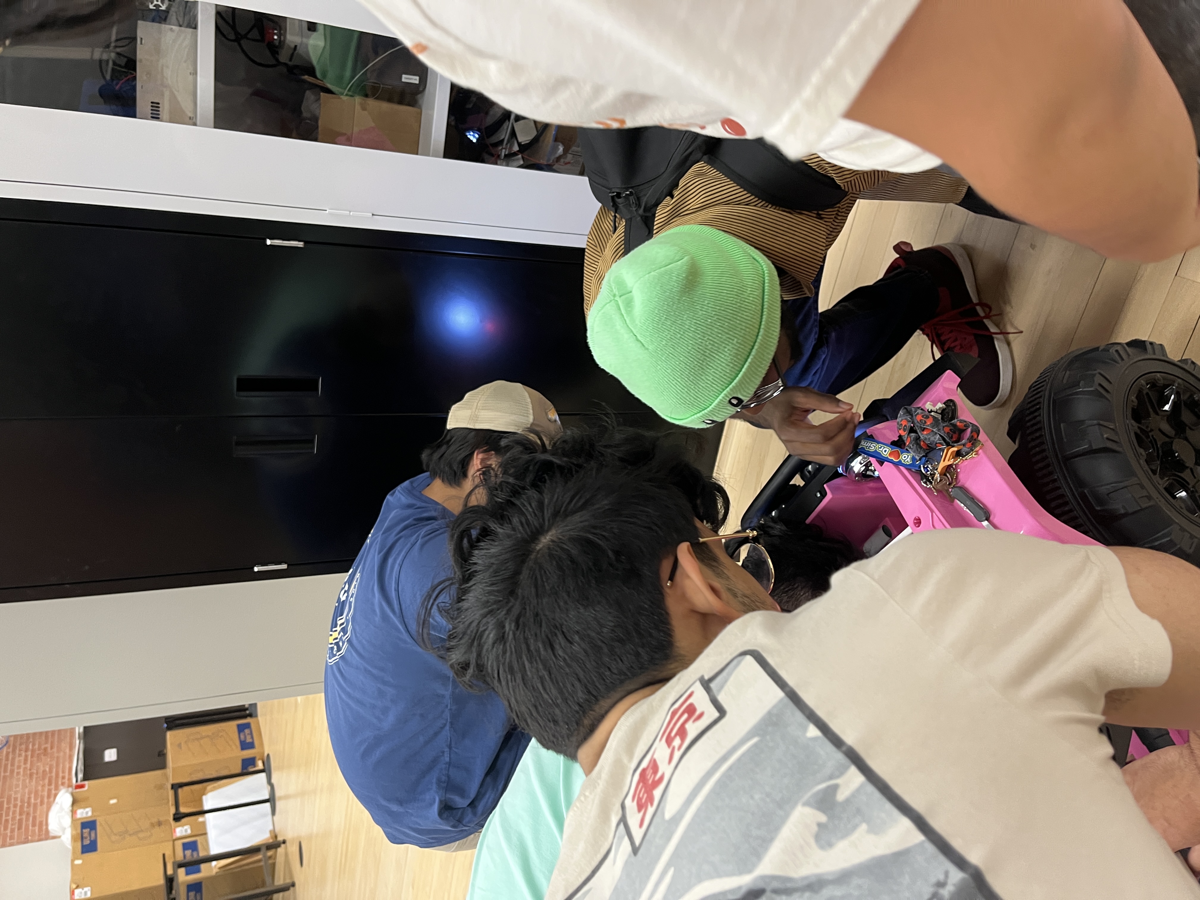 Three members working on ride-on car