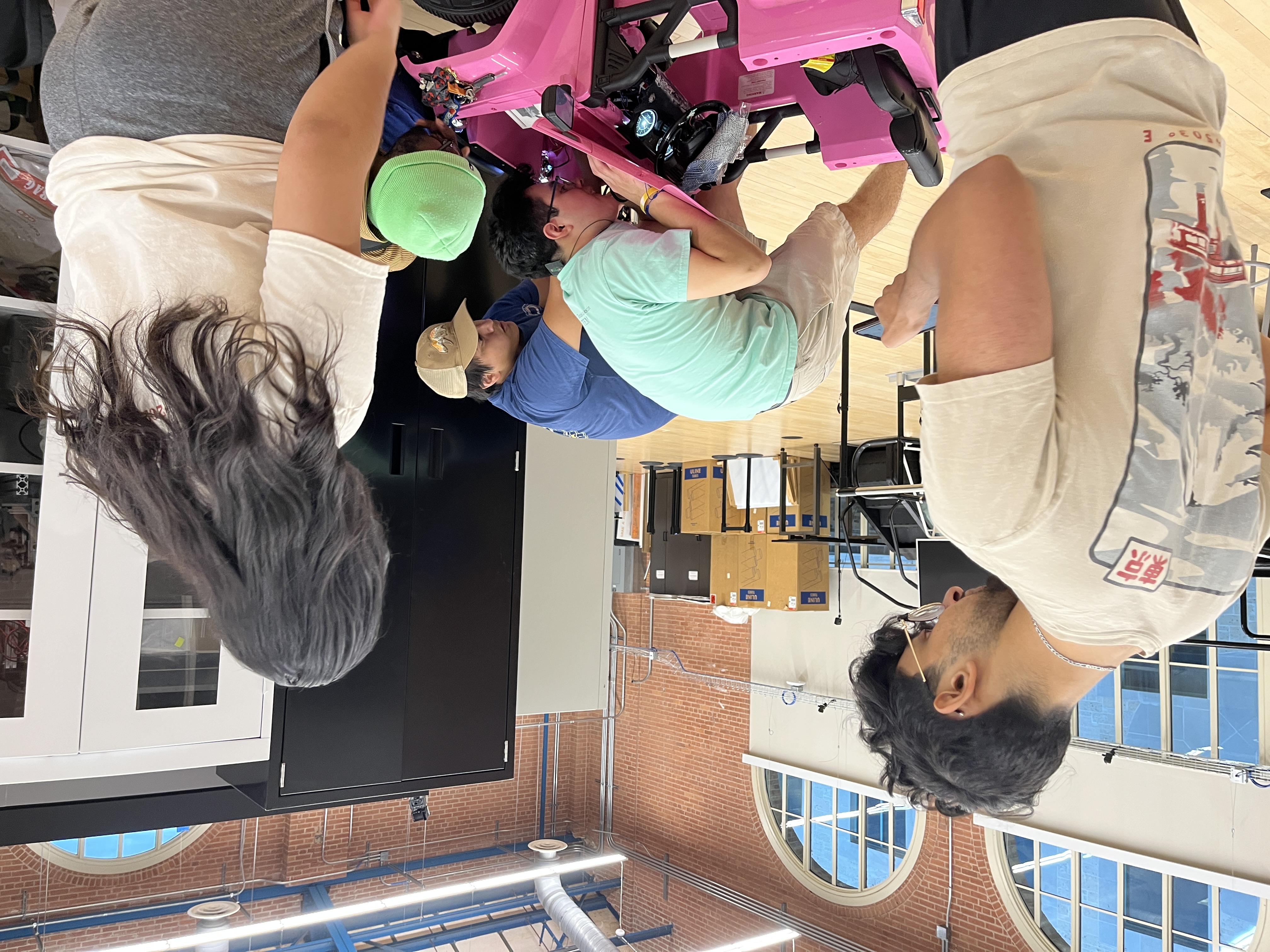 Members working on pink ride-on car